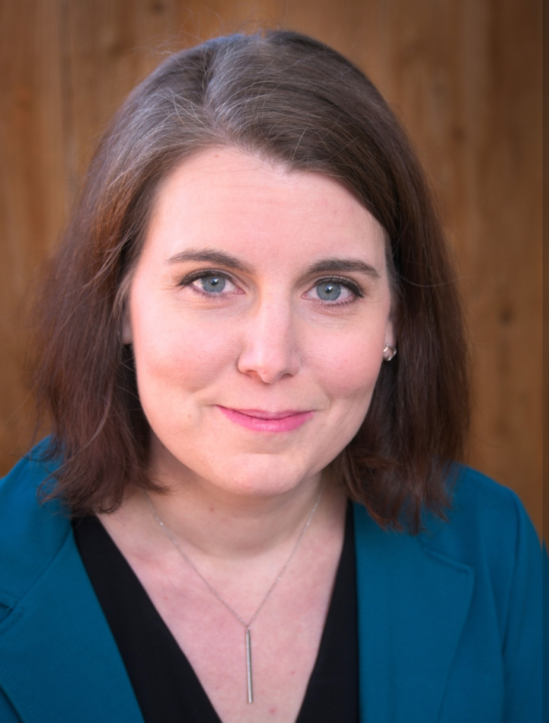 Headshot of Susan Metallo, a white woman with short brown hair, wearing a blue blazer and smiling