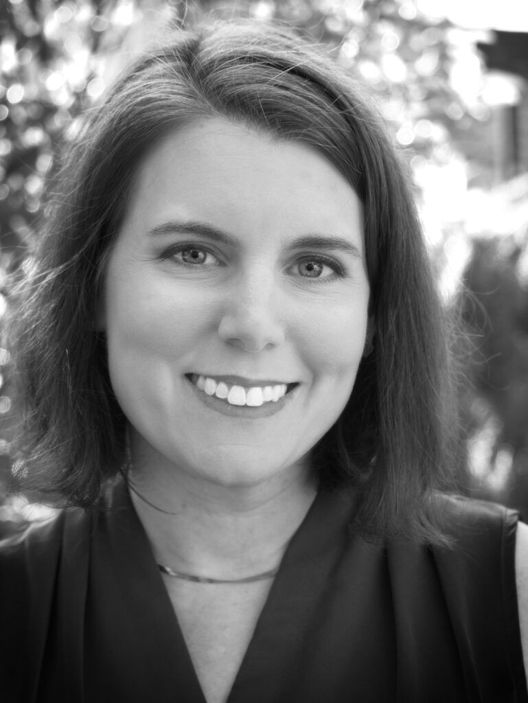 Black and White headshot of Susan Metallo, a white woman with short brown hair, smiling.