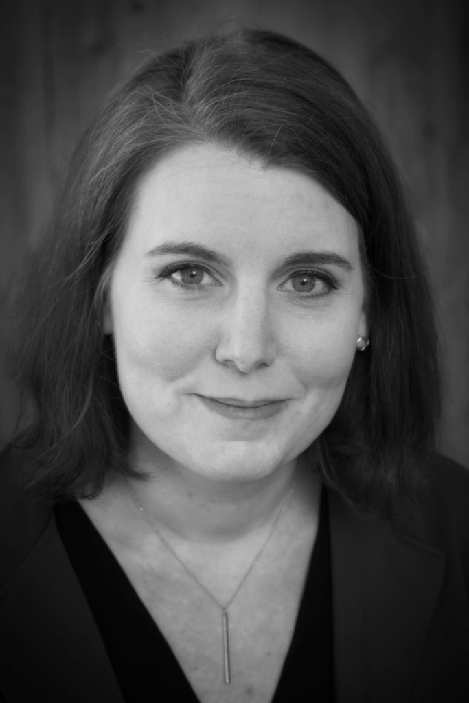 Black and white headshot of Susan Metallo, a white woman with shoulder length brown hair.